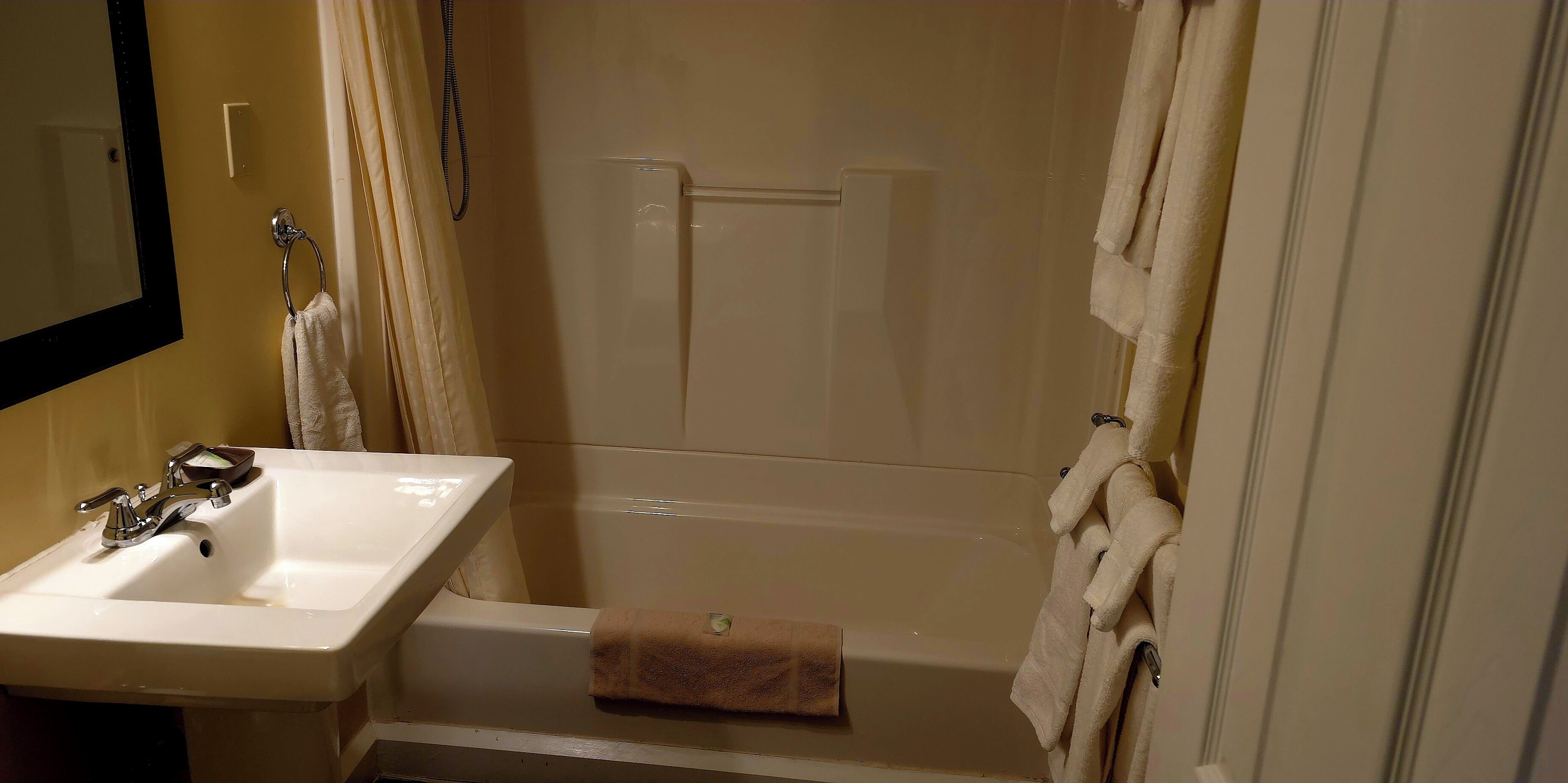 Un baño con lavamanos, bañera y cortina de ducha.