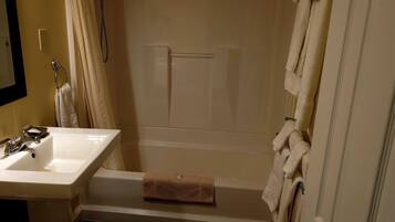 Un baño con lavamanos, bañera y cortina de ducha.