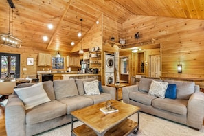 A log cabin interior with a living room, kitchen, and laundry area. - New Listing! Family Gameroom Cabin+Fire Pit+Hot Tub+Dog Friendly+Close to BR! (Morganton)