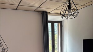 A bedroom with a bed, a window, a TV, and a ceiling light fixture. - Hotel beautiful stay in porto-ota 105 (Ota)