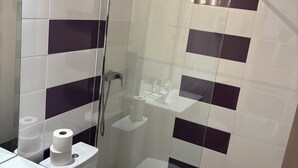 A modern bathroom with a glass-enclosed shower, a toilet, and a sink. - Hotel beautiful stay in porto-ota 105 (Ota)