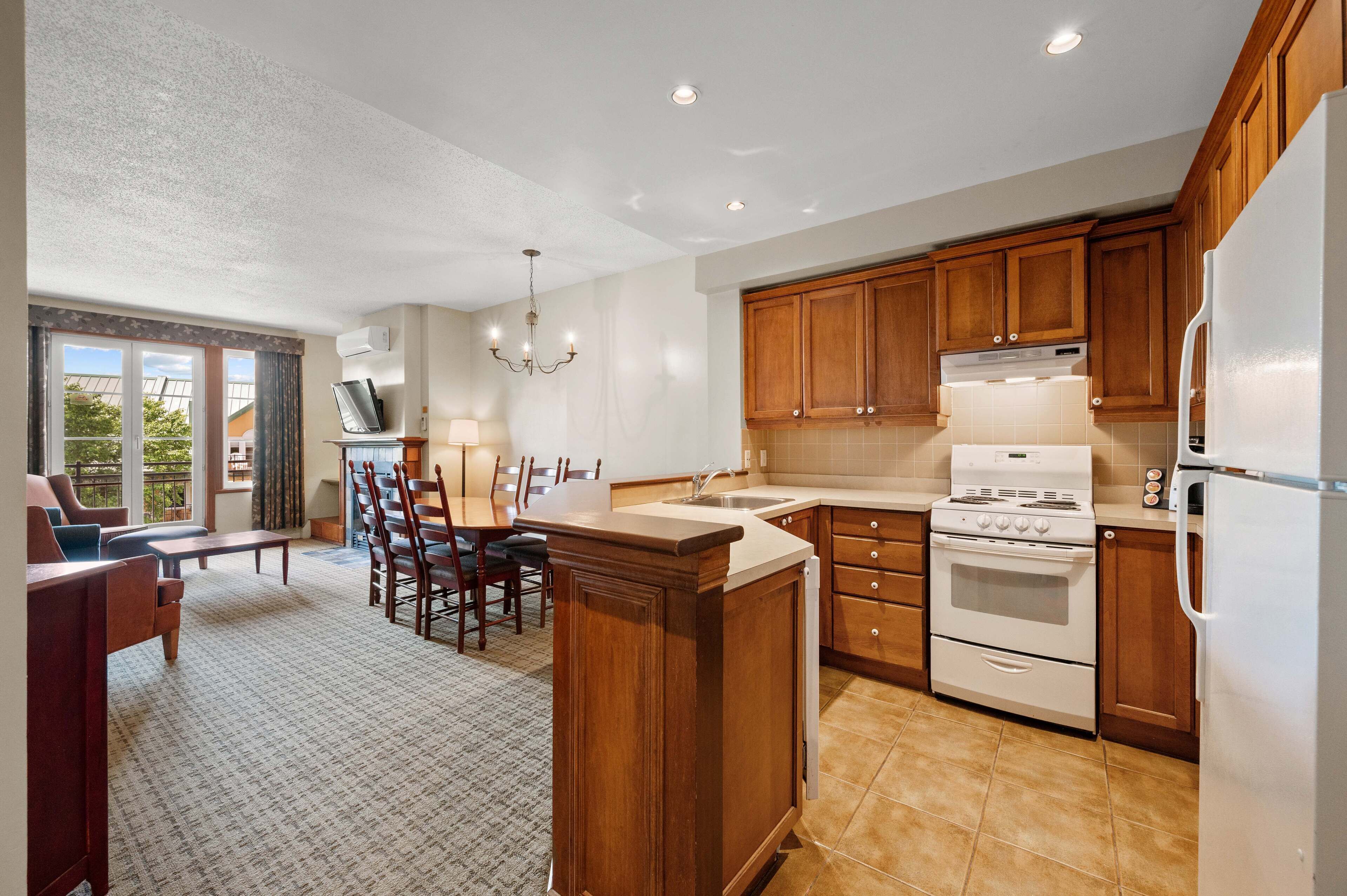 A kitchen with wooden cabinets, a white stove, and a large island.
