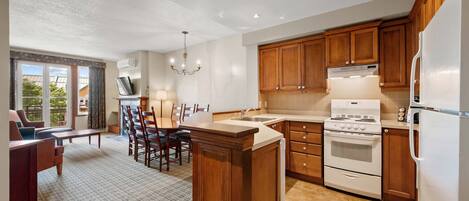 A kitchen with wooden cabinets, a white stove, and a large island.