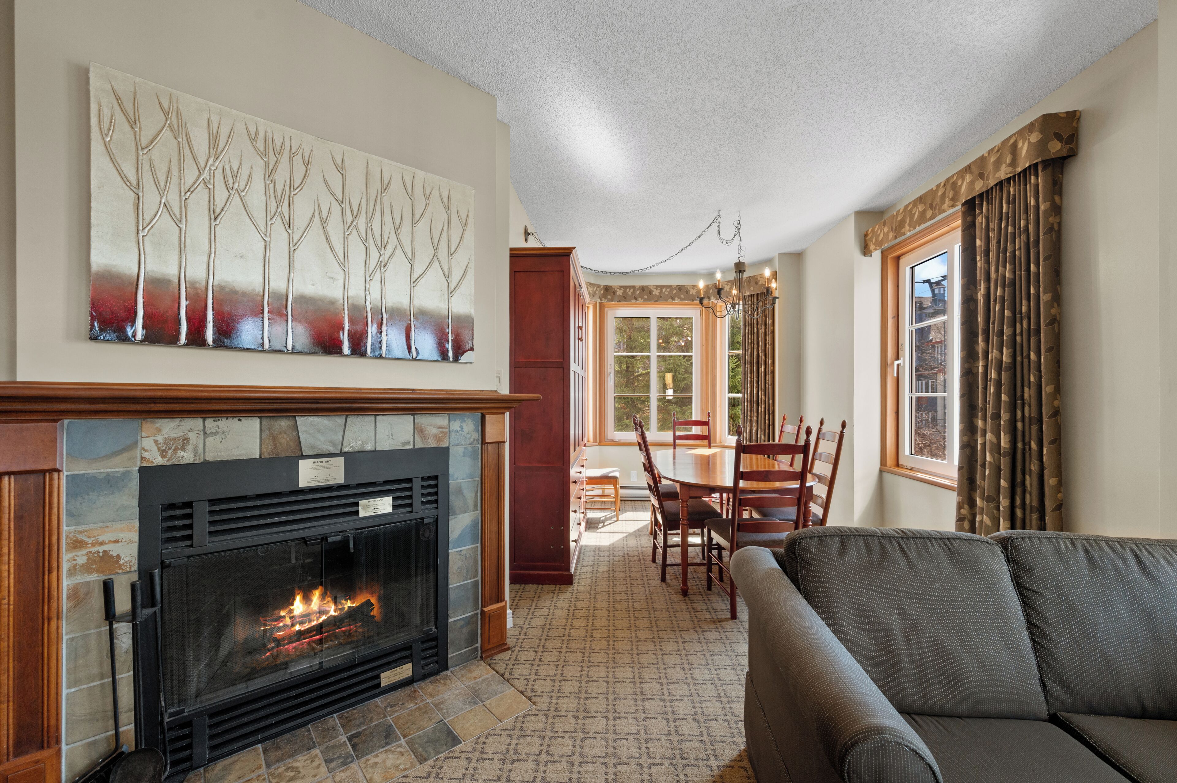 A living room with a fireplace, a dining table, and a sofa.