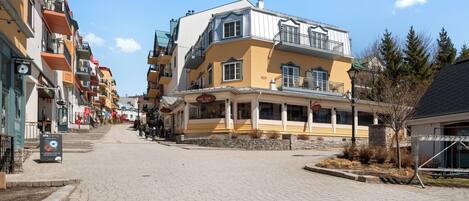 En gata med fler våningar, en restaurang som heter ”PIZZA TERIO” och en skylt för ”MUSICAL GALLERY”.