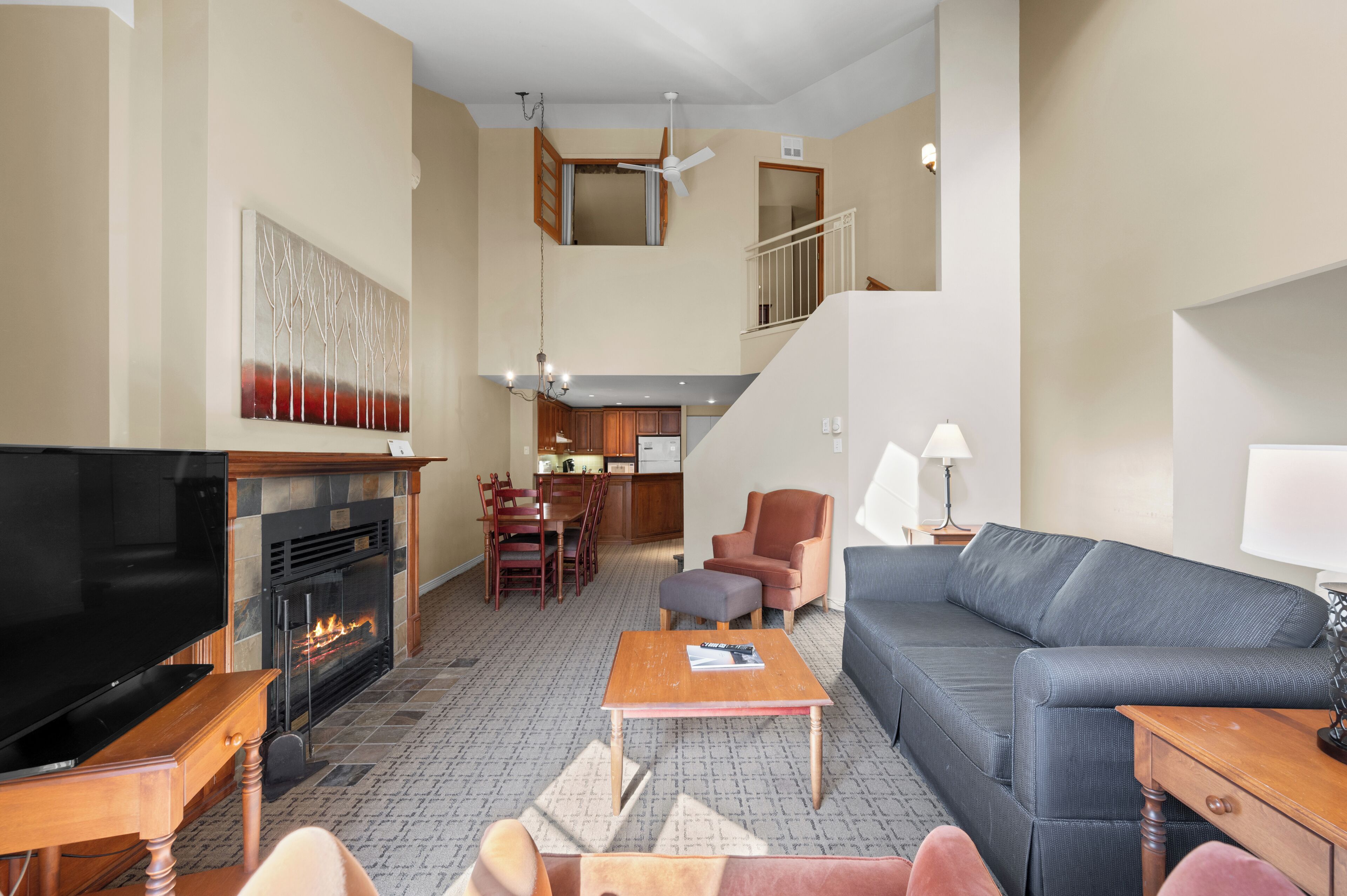 Un amplio salón con chimenea, televisor, sofá y zona de comedor.