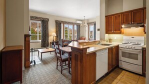 A kitchen with a central island, a stove, and a sink. - Le Deslauriers by RVMT (Mont-Tremblant)
