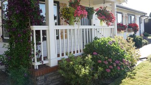 Une maison avec un porche, des jardinières suspendues et des fondations en briques.