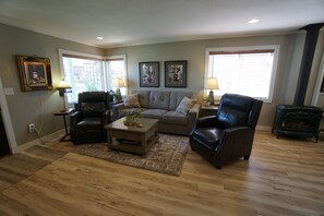 A living room with a sofa, two armchairs, a coffee table, and a fireplace. - Modern European getaway. . WORLD CUP 2026 train (Puyallup)
