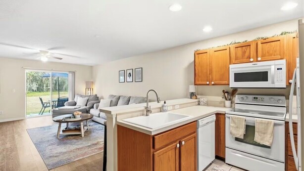 A modern kitchen with wooden cabinets, a white countertop, and a built-in microwave. - 2BR Townhome, Private, Monthly Stays Welcome! (Land O' Lakes)