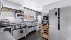 Una cocina equipada con estufa, horno, microondas, refrigerador y una alacena para vinos.
