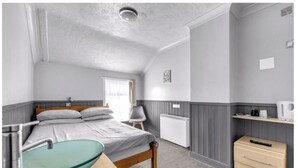 A bedroom with a bed, bedside table, lamp, and a view of the bathroom. - Mallow View Guest House | Cleethorpes Beachside (Cleethorpes-Mallow View Guest House)
