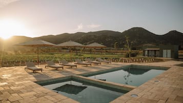 Una piscina al aire libre, tumbonas