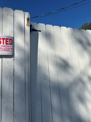 A white wooden fence with a sign indicating the property is private and trespassing is prohibited. - The Starland, Sweet House, blue pet friendly. (Savannah)