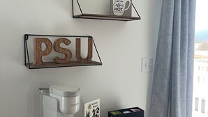 A coffee station with a coffee maker, a sign that says 'Coffee,' a shelf with a mug saying 'I like my coffee hot,' and a welcome sign. - The Nittany House in Bellfonte (Bellefonte)