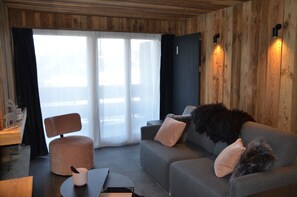 A modern interior with a sofa, ottoman, and a small table. - Discover this superb 3.5-room premium apartment, completely renovated with quality materials, combin (Thyon-Les Collons)