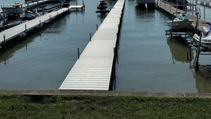 Une jetée s’avançant dans une étendue d’eau calme, avec des bateaux amarrés à chaque extrémité.