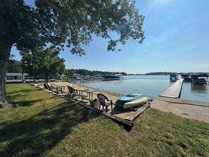 A lakeside park with picnic tables, a canoe, and a dock extending into the water. - Diamond Lake Hideaway (Cassopolis)