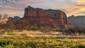 A natural landscape with a prominent rock formation, sparse vegetation, and a clear sky. - Toroweap- Sedona Bell Rock Views (Sedona)