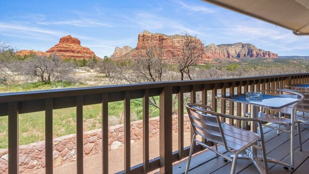 A deck with a table and chairs overlooking a desert landscape with red rock formations. - Toroweap- Sedona Bell Rock Views (Sedona)