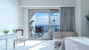 Une chambre d’hôtel moderne avec un balcon, un coin repas et un canapé.