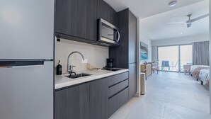 Une cuisine moderne équipée d’un four à micro-ondes encastré, d’un évier et d’une machine à café.