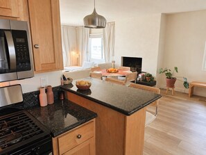 A modern kitchen with a central island, wooden cabinets, a built-in microwave, and a gas stove. - Bright Studio City apartment with dedicated workspace (Los Angeles)