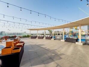 Eine Dachterrasse mit Außenbereich, einem Pool und Lichterketten.