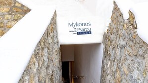 Una escalera de piedra que conduce a una habitación con un letrero que dice 'Mykonos The Psarou Dreaming Place'.