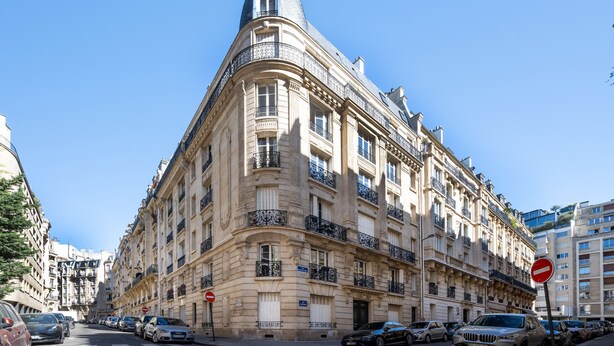 A historic building with classical architecture, a street view, and parked cars. - The Haussmann-style Sarcey - Welkeys (Paris)