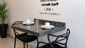 Een moderne eethoek met een tafel, stoelen en een potplant.