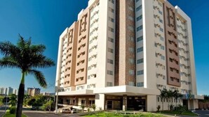 A multi-story hotel with a curved facade, a central vertical feature, and a landscaped entrance. - Le Jardin Suites - Caldas Novas (Caldas Novas)
