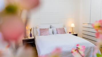 A bedroom with a bed, nightstands, a lamp, and a wardrobe.