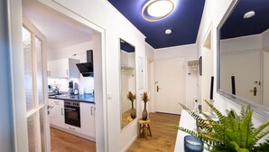 A modern kitchen with white cabinets, a built-in oven, and a coffee machine. - Charmante Wohnung in Koblenz (Koblenz)