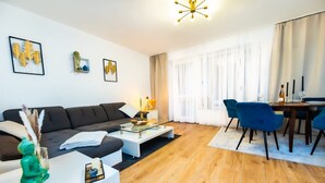 A modern living room with a sofa, coffee table, and dining area. - Charmante Wohnung in Koblenz (Koblenz)