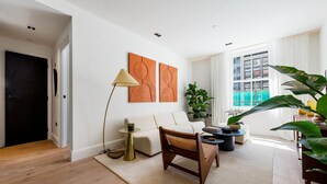 A modern living room with a sofa, a chair, a coffee table, and artwork on the wall. - The Pembridge Residences Building (London)