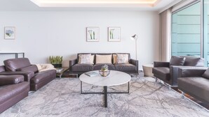 A modern living room with a marble floor, leather sofas, a round coffee table, and framed artwork on the walls. - La Belle Vie by Atlantic Holiday (Funchal)
