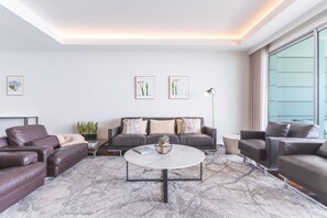A modern living room with a marble floor, leather sofas, a round coffee table, and framed artwork on the walls. - La Belle Vie by Atlantic Holiday (Funchal)