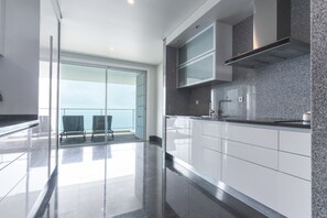 A modern kitchen with a glass door leading to a balcony, stainless steel appliances, and a granite countertop. - La Belle Vie by Atlantic Holiday (Funchal)