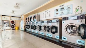 A laundry facility with multiple washing machines, each labeled with capacity and size. - 401 Budget Room Utilities Wifi Balcony in Ratchada (Bangkok)