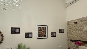 A room with a chandelier, framed artwork on the wall, a stone accent wall, and a nightstand with a vase. - Room-b&b Porta Verde - Dorothy Room (Castelbottaccio)