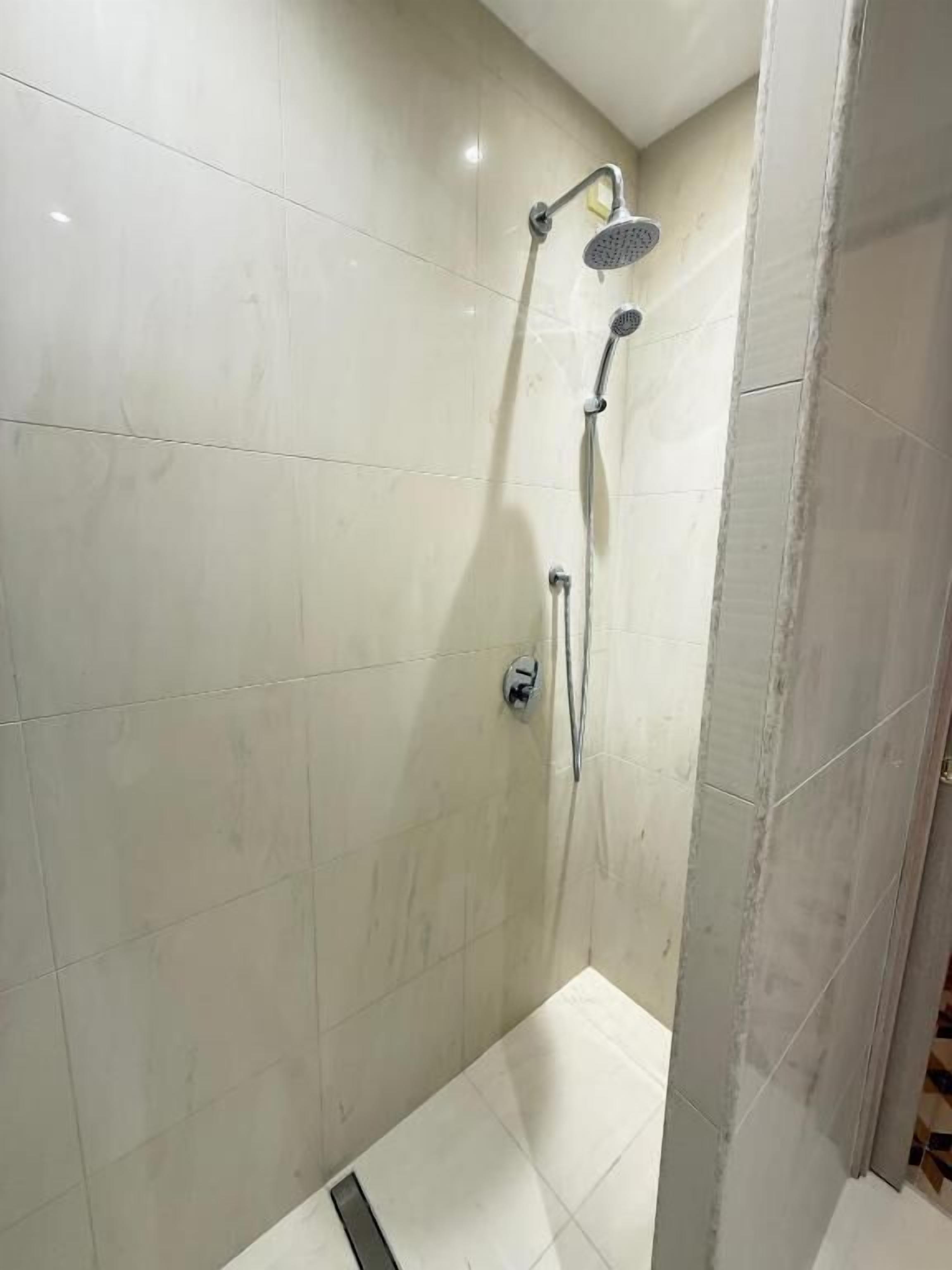 Ducha con cabezal de ducha de mano y grifo empotrado.
