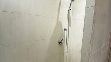 Ducha con cabezal de ducha de mano y grifo empotrado.