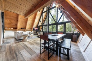 Ein geräumiges Loft mit hohen Decken, großen Fenstern, einem Essbereich und einer gemütlichen Sitzecke.