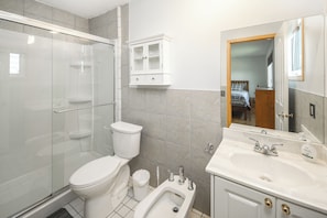 A bathroom with a glass shower enclosure, a toilet, a bidet, a sink with a mirror, and a cabinet. - Nice 3 Bedroom Double Garage Fully Fence Yard Close to Stempede 10 mins to DT (Calgary)