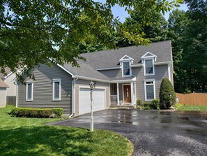 A two-story house with a garage, a front porch, and a well-maintained lawn. - The Perfect Location in Saratoga Springs (Saratoga Springs)