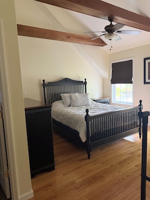 A bedroom with a wooden bed, a ceiling fan, a window with a blind, and a radiator. - The Perfect Location in Saratoga Springs (Saratoga Springs)