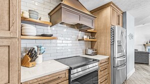 Una cucina moderna con mobili in legno, un frigorifero in acciaio inossidabile e un forno integrato.