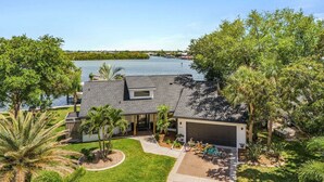 Una casa con garage, una piccola struttura adiacente e vista su un lago.