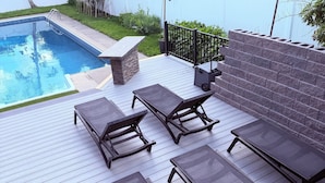 Una terrazza con mobili da esterno, una piscina e un focolare in pietra.